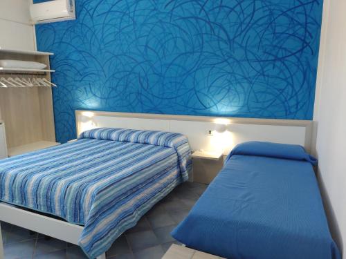 een slaapkamer met een bed en een blauwe muur bij Bed and breakfast Delfino Blu in Torre Vado