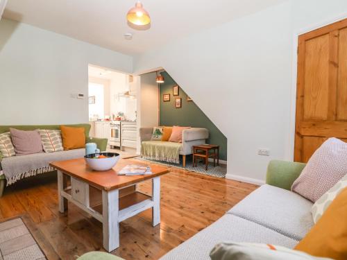 a living room with two couches and a table at Sea Mouse Cottage in Southwold