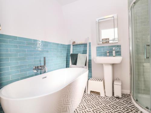 ein Badezimmer mit Badewanne und Waschbecken in der Unterkunft Sea Mouse Cottage in Southwold