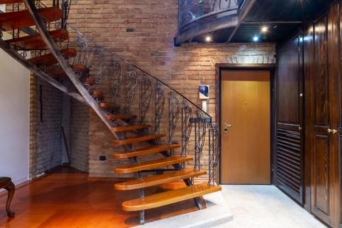 a spiral staircase in a room with a brick wall at Penthouse Sky in Sarajevo