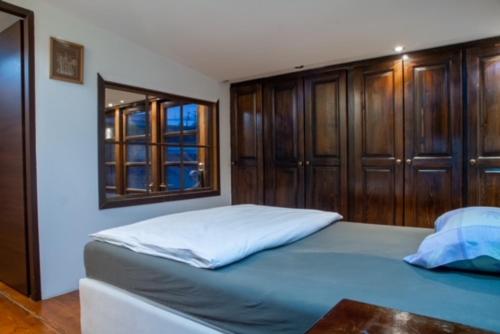 a bedroom with a blue bed with wooden cabinets at Penthouse Sky in Sarajevo