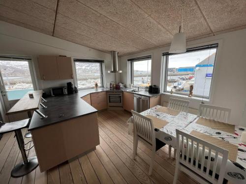 uma cozinha e sala de jantar com mesa e cadeiras em Kang Apartment em Nuuk