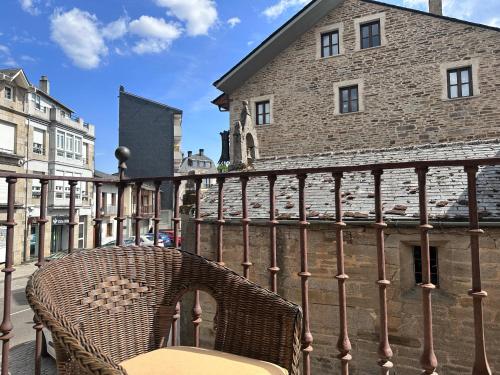 a wicker chair sitting on a balcony next to a building at Alojamiento Luz de Hadas in Sampil