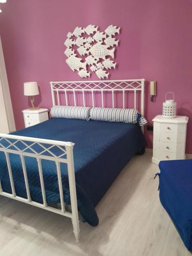 um quarto com uma cama e uma parede roxa em Loving Salento em Porto Cesareo