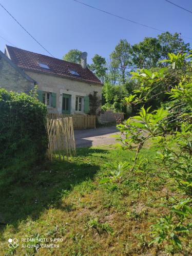 uma casa com uma cerca em frente a um quintal em Le gîte "La belle époque" classé 3 Etoiles em Tanlay