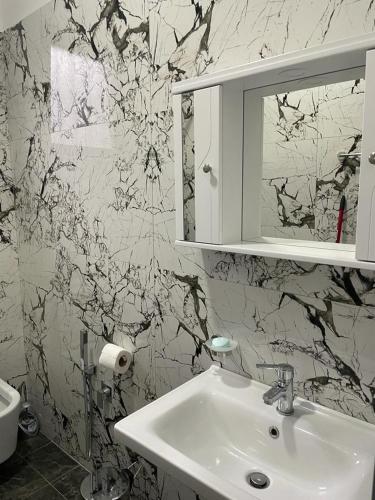 een badkamer met een wastafel en een spiegel bij Taku apartment in Sarandë