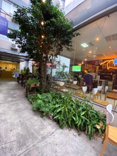 a restaurant with tables and chairs and a tree at Hotel Juramento in Buenos Aires