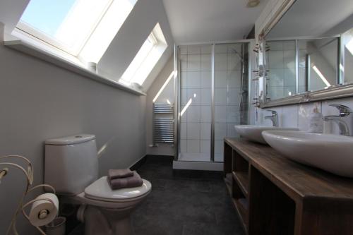 リー・オン・ザ・ソレントにあるImmaculate 4BD Family Home in Lee on the Solentのバスルーム(洗面台2台、トイレ付)、窓が備わります。