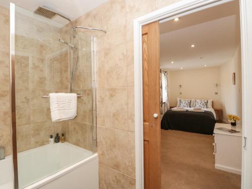 a bathroom with a shower and a tub and a bed at Spanish Boathouse in Brixham