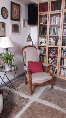 a living room with a chair with a red pillow at Casa rural y B&B la Perla in Hiendelaencina