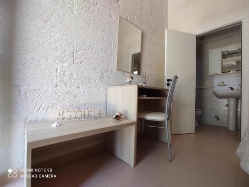 Cette chambre comprend un bureau, une chaise et un lavabo. dans l'établissement Masseria Don Egidio, à Melendugno