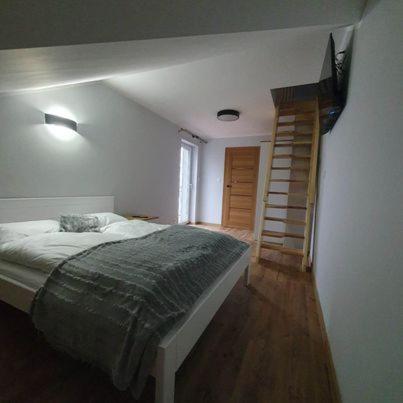 a bedroom with a bed and a staircase in it at Agroturystyka Koronkowe Zacisze in Koniaków