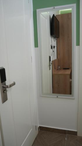 a bathroom with a mirror and a white door at Hotel Luris in Golem