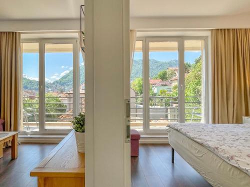 a bedroom with a bed and a large window at Central Premium Apartment in Braşov