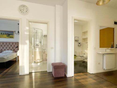 een badkamer met een douche en een slaapkamer met een bed bij Central Premium Apartment in Braşov
