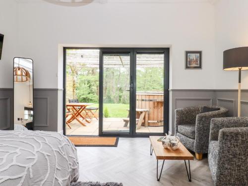 a bedroom with a bed and a chair and a table at The Snug at Pickelden Farmhouse in Canterbury
