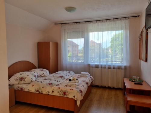 a small bedroom with a bed and a window at Pensiunea Coca in Baile Felix