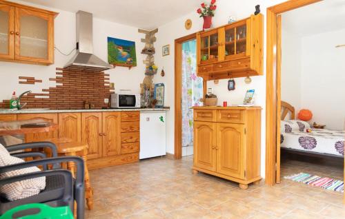 cocina con armarios de madera y cama en Casa GRENADO, en Vallehermoso