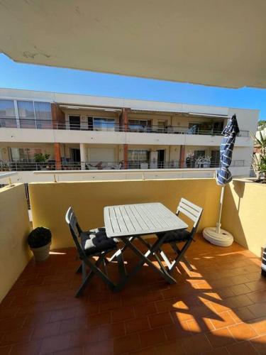 - un balcon avec une table et des chaises dans l'établissement Superbe studio au bord de la mer à Sete, à Sète