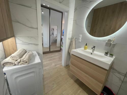 a white bathroom with a sink and a mirror at Apartament Kameralis Old Town - klimatyzacja - balkon - winda in Elblag