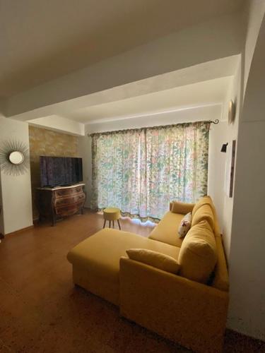 een woonkamer met een bank en een televisie bij Apartamento Girassol in Luz