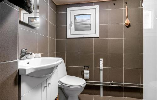 La salle de bains est pourvue de toilettes et d'un lavabo. dans l'établissement Pet Friendly Home In Thyholm With Kitchen, à Thyholm