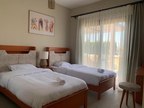 2 Betten in einem Hotelzimmer mit Fenster in der Unterkunft Luxurious Villa with Infinity Private Pool & Jacuzzi over Sabina Island's Lagoon in Hurghada