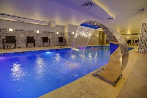 a swimming pool with a water fountain in a building at De-Lara hotel in Aqaba