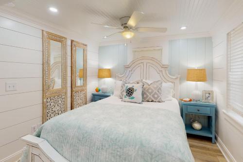1 dormitorio blanco con 1 cama grande y mesas azules en Jewel's Cottage, en Demere Park