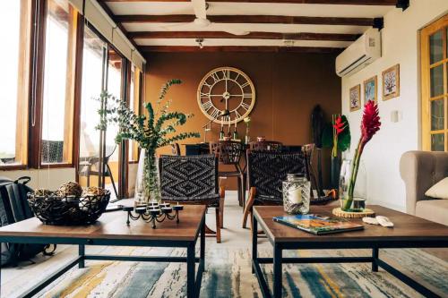 a living room with two tables and a clock on the wall at 7CN-3 CASA DE 7 HABITACIONES EN EL CENTRO HISTORICO in Cartagena de Indias