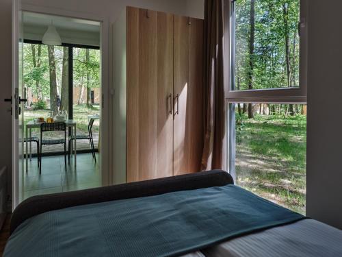 a bedroom with a bed and a large window at Kaletka - cisza i przyroda in Iława