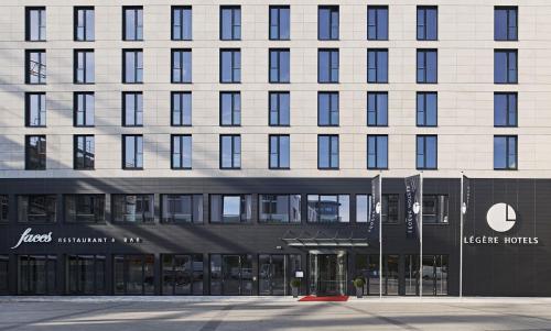 a large building with a sign in front of it at LÉGÈRE HOTEL Bielefeld in Bielefeld