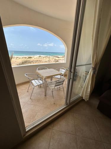 a balcony with a table and chairs and the beach at sea View Nautilus free wi-fi Sal Rei in Sal Rei