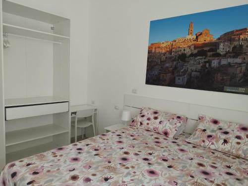 a bedroom with a bed and a painting on the wall at Le stanze del Maestro in Matera