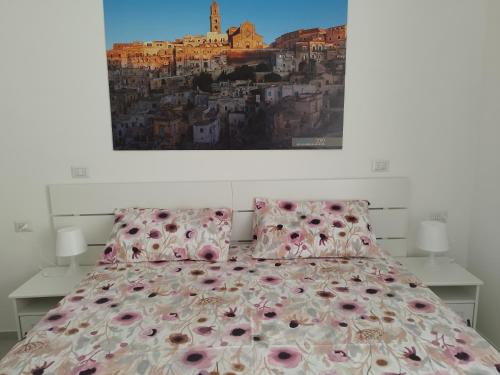 Un dormitorio con una cama con almohadas rosas y una pintura en Le stanze del Maestro, en Matera