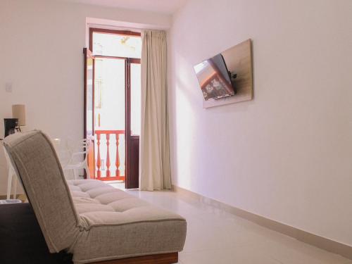 a living room with a chair and a tv on a wall at Hotel Casa Agustina in Cartagena de Indias