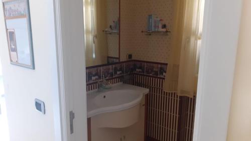 ein Badezimmer mit einem weißen Waschbecken und einem Spiegel in der Unterkunft Relais dei due Mari in Carmiano