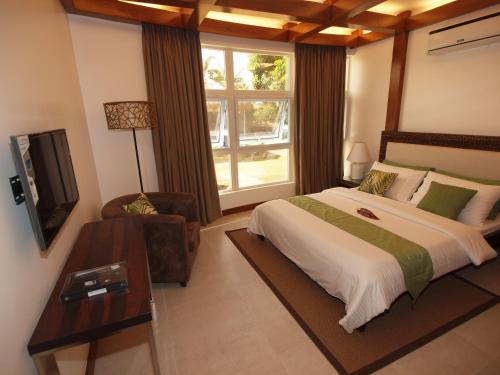 une chambre avec un grand lit et une fenêtre dans l'établissement Vida Homes Condo Resort, à Dauin