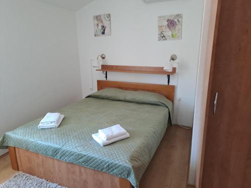 a bedroom with a bed with two towels on it at Sobe MaMaLu in Valun