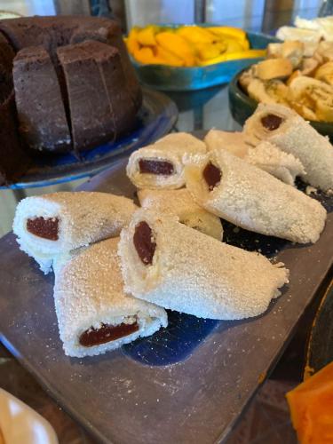 Una bandeja de pasteles sobre una mesa con pasteles de chocolate. en Pousada Papaya Container, en Ubatuba