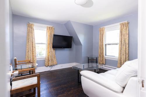 a living room with a couch and a tv at Hillside Motel in Saint John