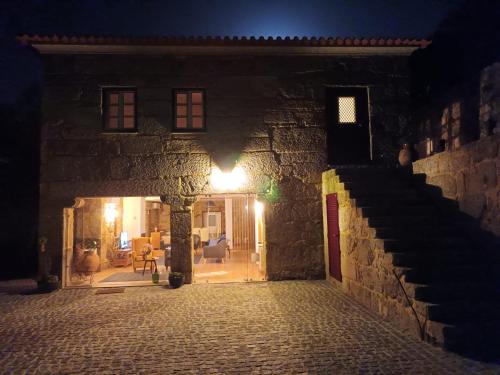 an entrance to a stone building at night at Casa de Ferrapilhe in Paranhos
