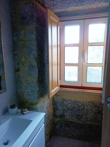 a bathroom with a window and a white sink at Casa de Ferrapilhe in Paranhos