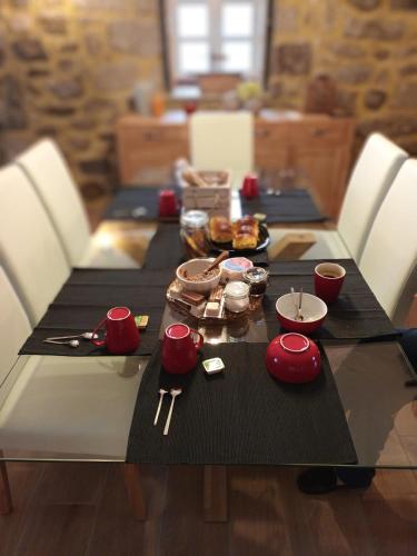 ein langer Esstisch mit schwarzen Matten und rotem Geschirr darauf in der Unterkunft Casa de Ferrapilhe in Paranhos