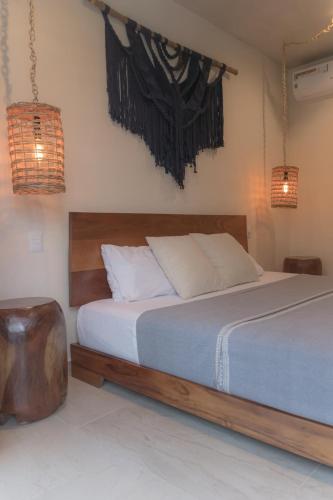 a bedroom with a bed with a wooden head board at Stylish Condo for 4 Rooftop & Pool Access in Tulum