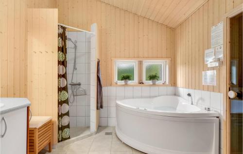 エーベルトフトにあるNice Home In Ebeltoft With 3 Bedrooms, Sauna And Wifiのバスルーム(大型バスタブ、シャワー付)