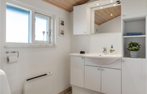 een witte badkamer met een wastafel en een spiegel bij Awesome Home In Hirtshals With Kitchen in Hirtshals