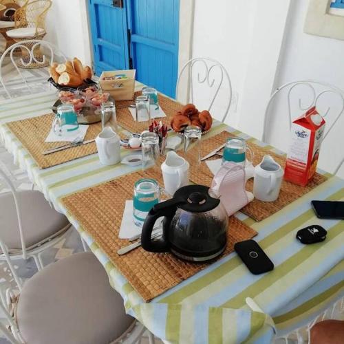 stół z dzbankiem do herbaty i inne przedmioty na nim w obiekcie Coeur des iles w mieście Mellita