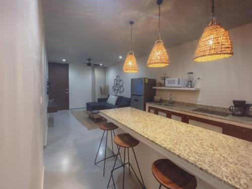 a kitchen with a counter and bar stools at Stylish Condo for 4 Rooftop & Pool Access in Tulum