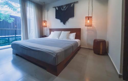 a bedroom with a large bed and a large window at Stylish Condo for 4 Rooftop & Pool Access in Tulum